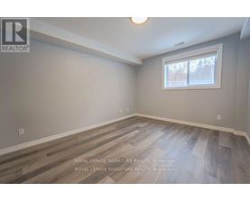 A room with a window and wooden flooring is for sale.
