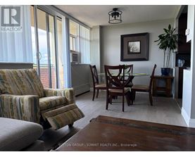 A living room with a couch, chair, and dining table.