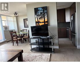 A living room with a flat screen TV and a dining table.