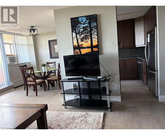 A living room with a flat screen TV and a dining table.