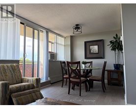 A dining room with a table set for two and a view of the outside.