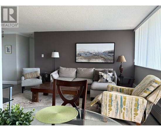 A living room with a couch, chair, and lamp.