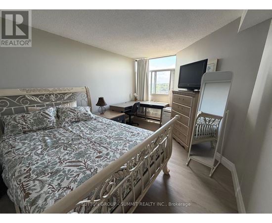 A bedroom with a large bed and a TV on a dresser.