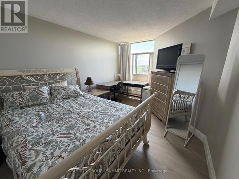 A bedroom with a large bed and a TV on a dresser.