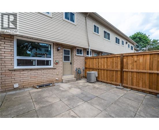 A house with a brown fence and a grey wall.