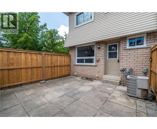 A backyard with a wooden fence and a concrete patio.