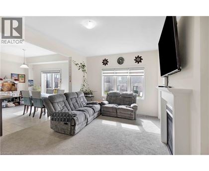 A living room with grey sofas and a television mounted on the wall.