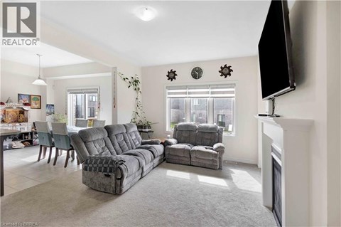 A living room with grey sofas and a television mounted on the wall.