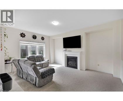 A living room with a grey sofa and a fireplace.