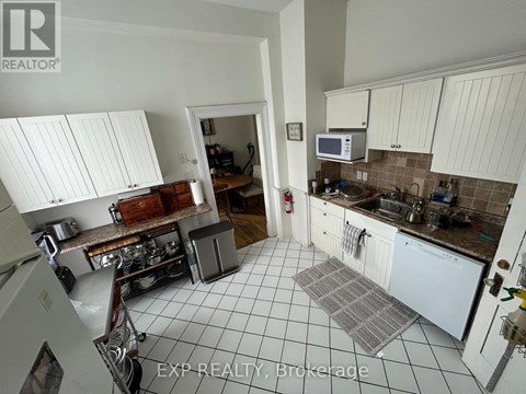 A kitchen with white cabinets and a tiled floor.