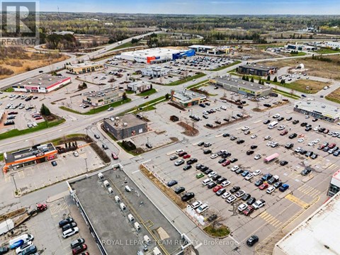 A parking lot with a large number of cars and a few buildings in the background.