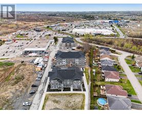 A bird's eye view of a residential area with houses and a shopping center.
