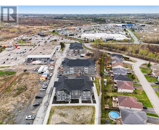 A bird's eye view of a residential area with houses and a shopping center.