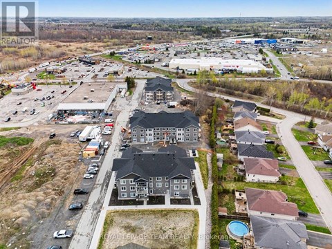 A bird's eye view of a residential area with houses and a shopping center.