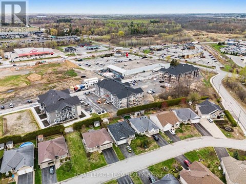 A bird's eye view of a residential area with houses and a shopping center.