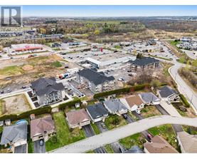 A bird's eye view of a residential area with houses and a shopping center.