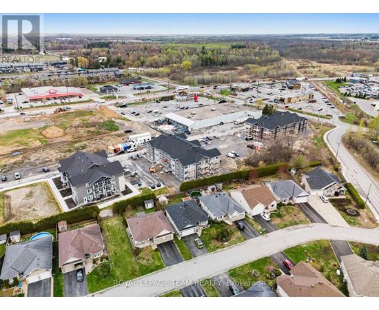 A bird's eye view of a residential area with houses and a shopping center.
