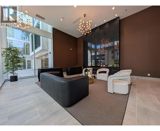 A modern living room with a black sofa and a glass wall.