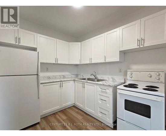 A kitchen with white appliances and cabinets.