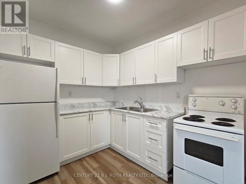 A kitchen with white appliances and cabinets.