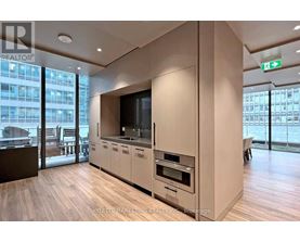 A modern kitchen with wooden floors and a large window.