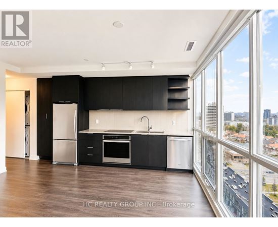 A modern kitchen with black cabinets and stainless steel appliances.