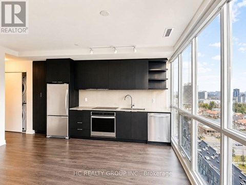 A modern kitchen with black cabinets and stainless steel appliances.