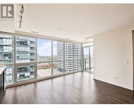 A room with a view of a cityscape through large windows.