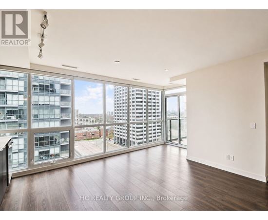 A room with a view of a cityscape through large windows.