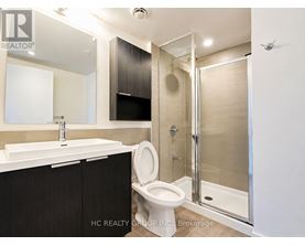 A bathroom with a toilet, sink, and shower.