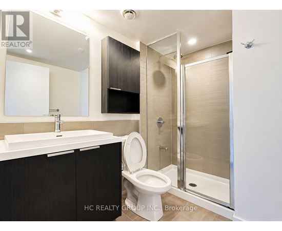A bathroom with a toilet, sink, and shower.