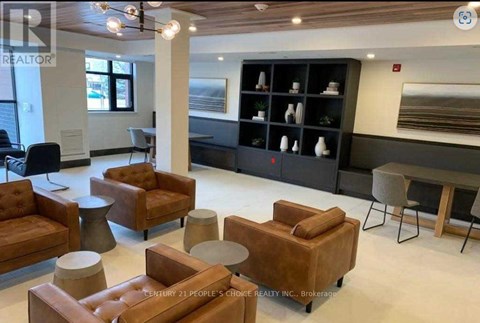 A modern living room with brown leather chairs and a black shelf with decorative items.