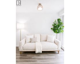 A white couch with a white blanket and pillows in a room.