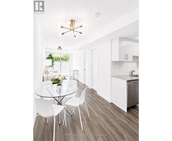 A modern kitchen with a glass table and white chairs.