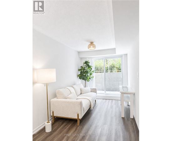 A bedroom with a large bed and a window overlooking a fence.