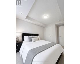 A bedroom with a bed, nightstand, and two doors.