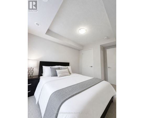 A bedroom with a bed, nightstand, and two doors.