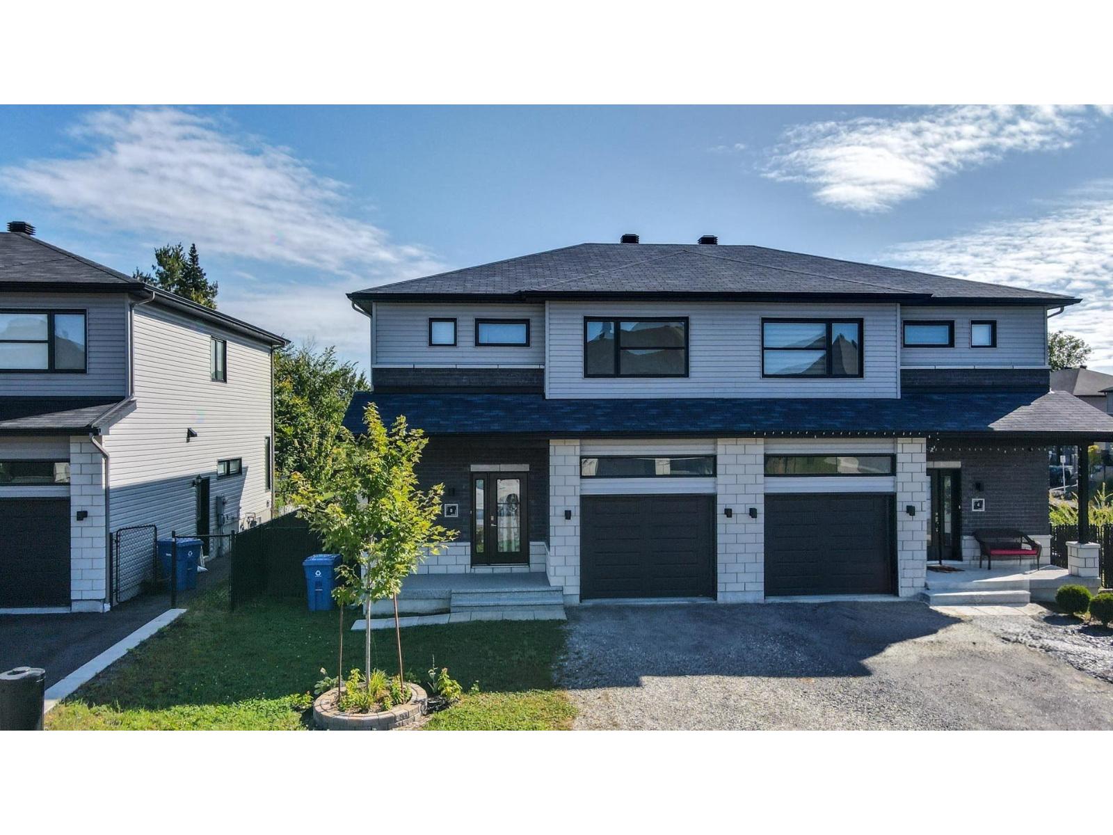 A modern two-story house with a garage and a driveway.