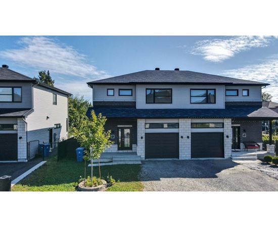 A modern two-story house with a garage and a driveway.