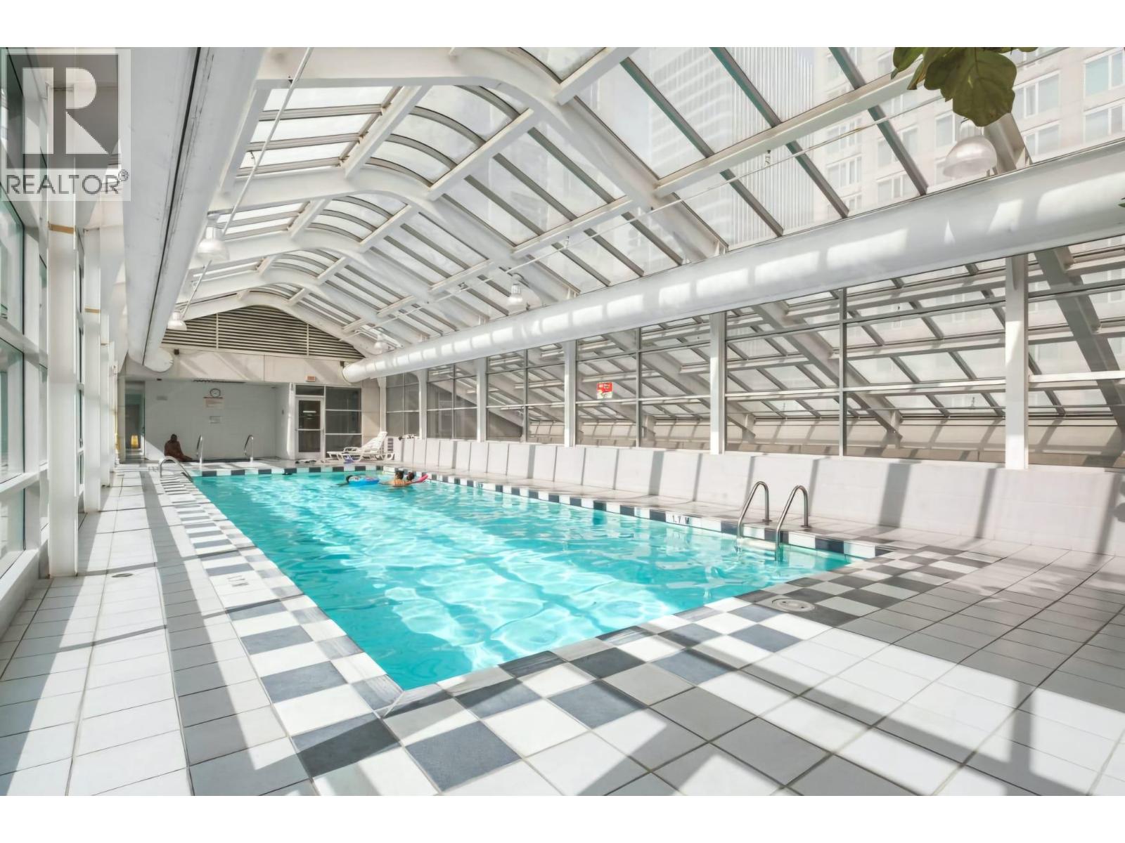 A large indoor swimming pool with a checkered floor.