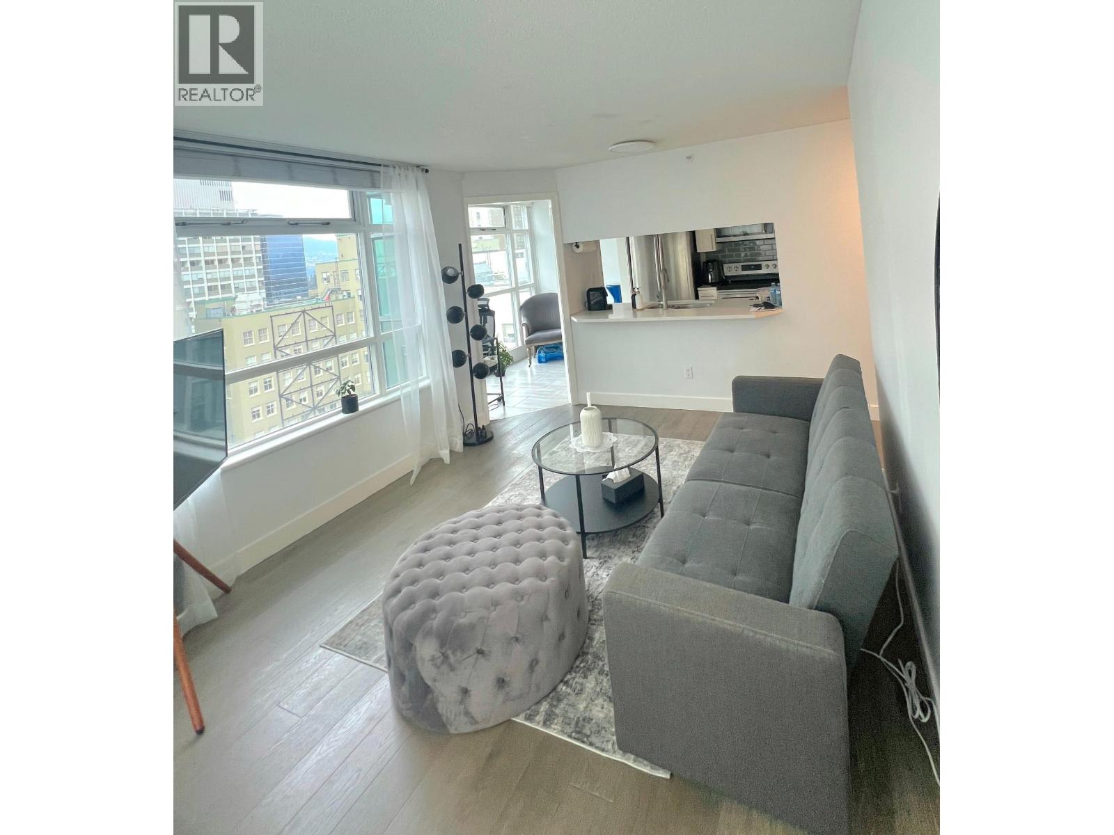 A living room with a grey couch and ottoman.