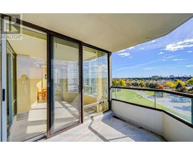 A balcony with glass doors overlooking a cityscape.