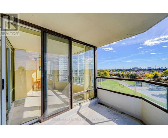 A balcony with glass doors overlooking a cityscape.