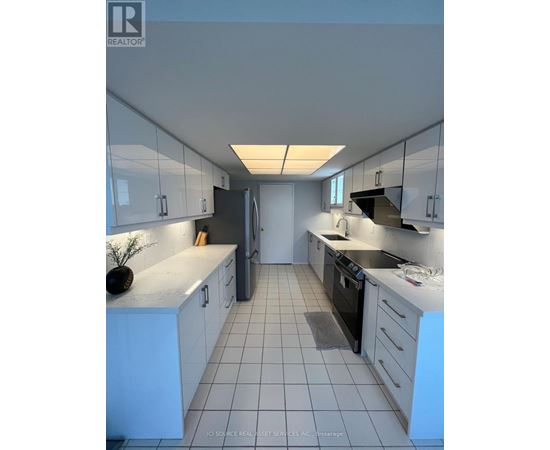 A kitchen with white cabinets and black appliances.
