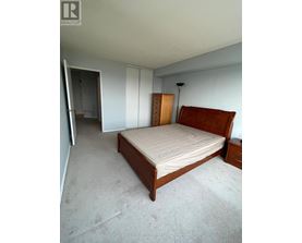 A bedroom with a bed, dresser, and mirror.