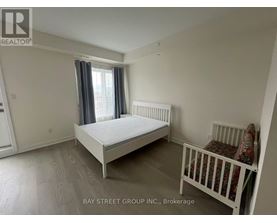 A bedroom with a white bed and a crib.