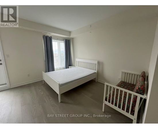 A bedroom with a white bed and a crib.