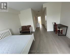 A bedroom with a bed, chair, and dining table.