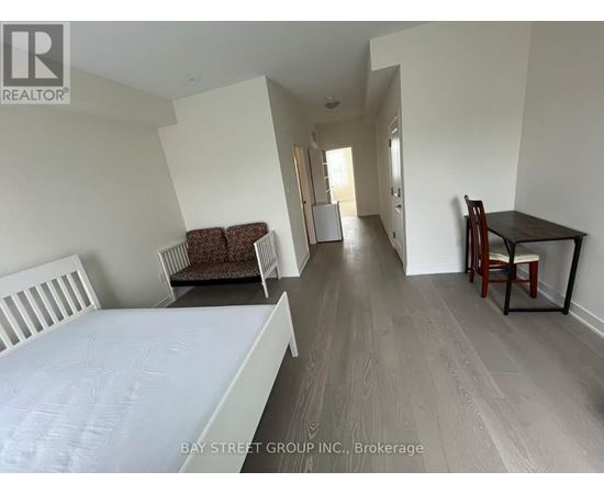 A bedroom with a bed, chair, and dining table.