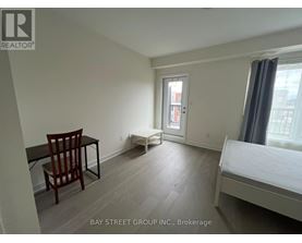 A bedroom with a bed, chair, and desk.